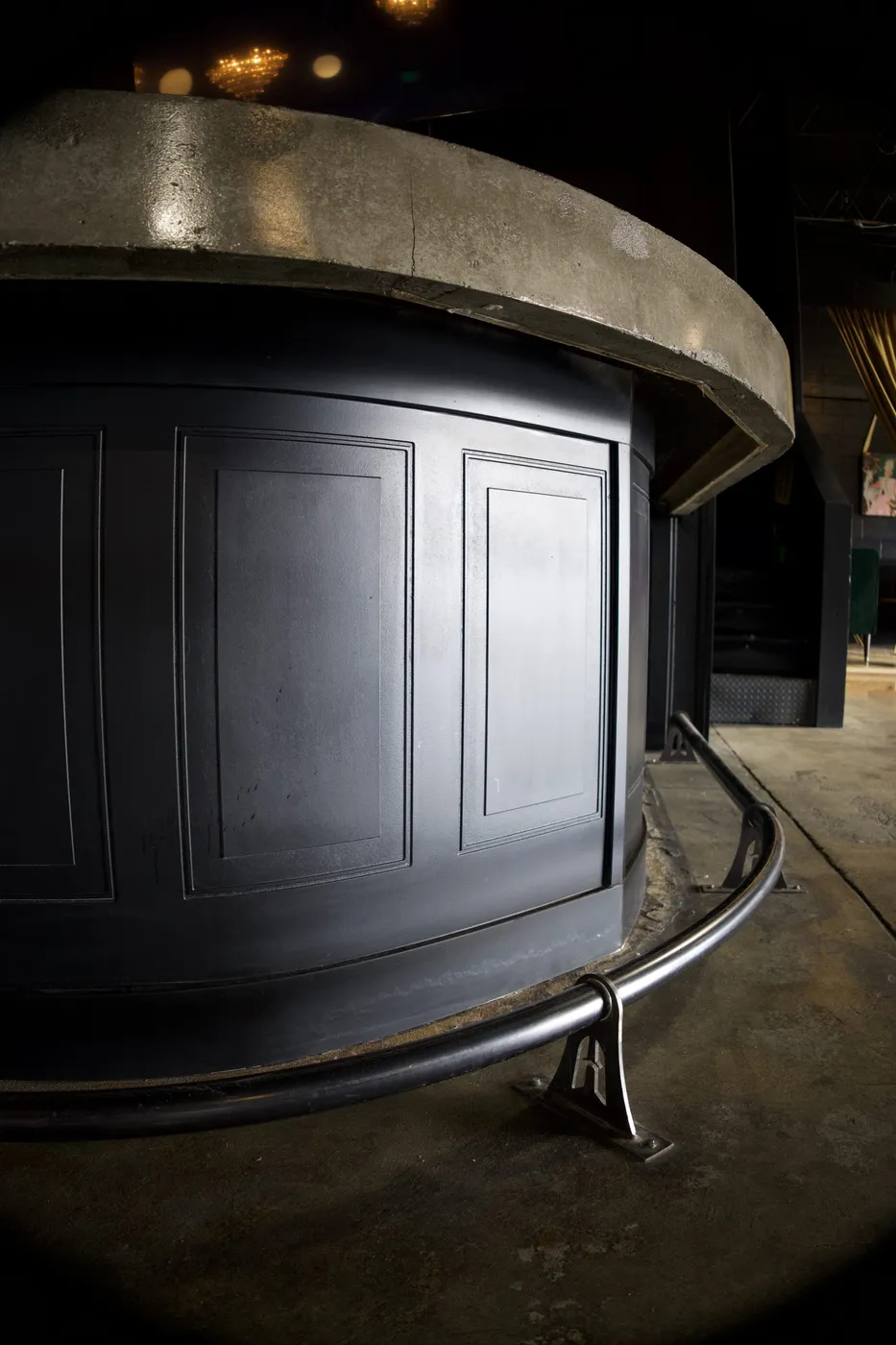 Detail of custom poured-concrete bar top and black paneled base