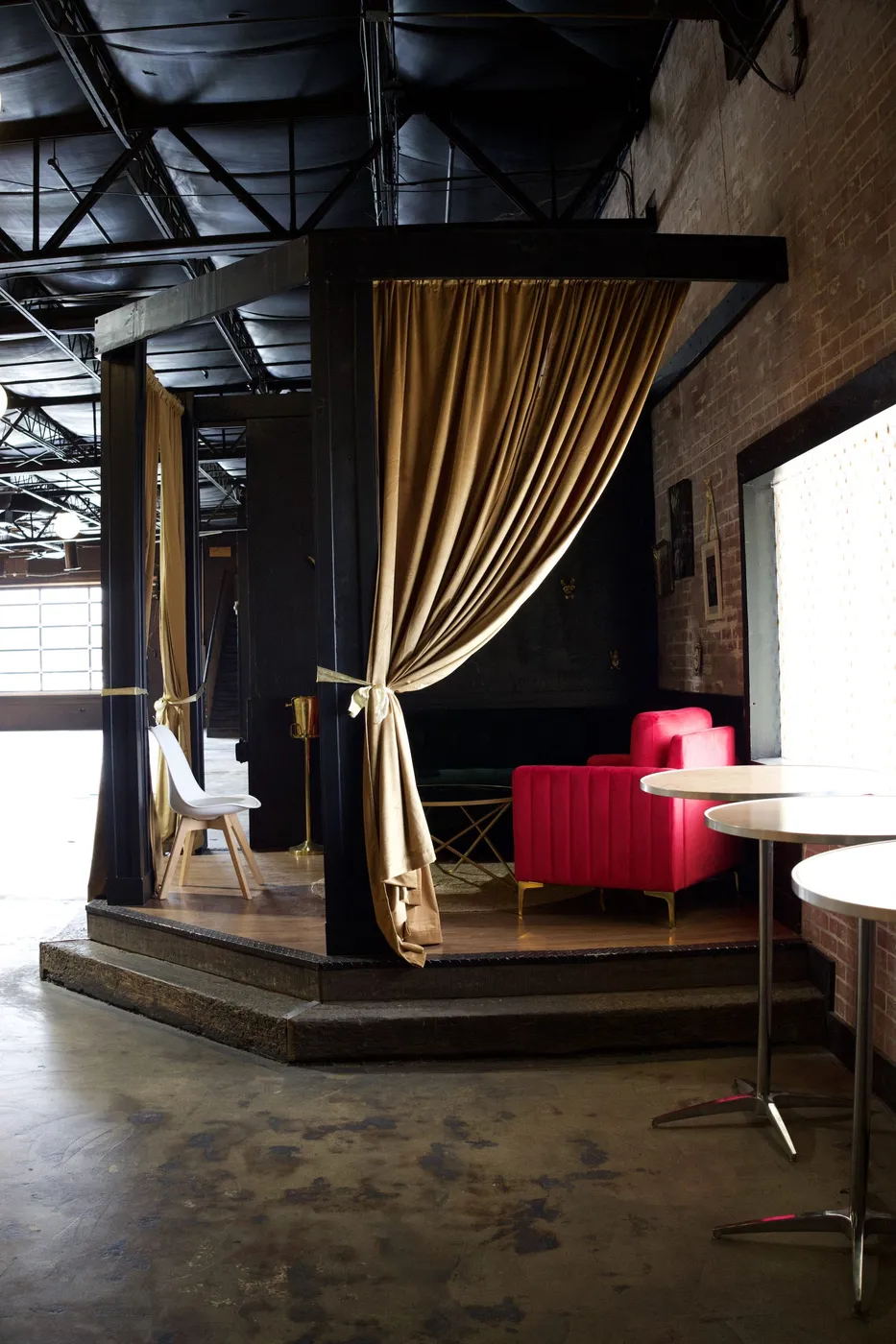 Lounge seating area with velvet curtains and cafe tables in Boise event venue remodel