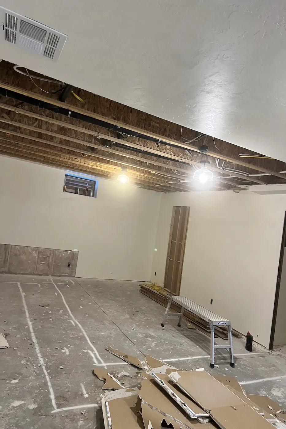 Open basement ceiling joists and demo stage during Boise renovation