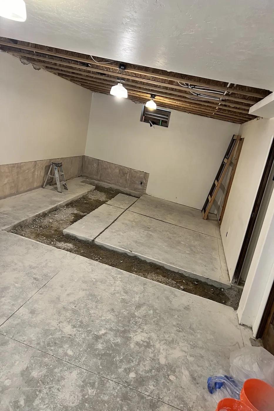 Unfinished basement concrete slab and framing before renovation in Boise