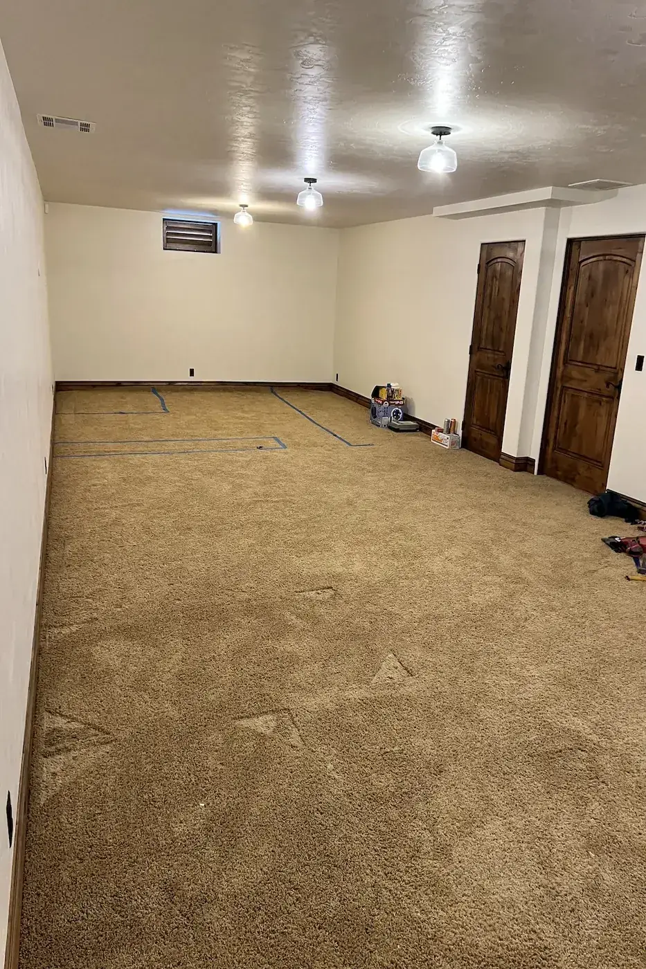 Finished basement rec room with carpet and custom wood doors in Boise