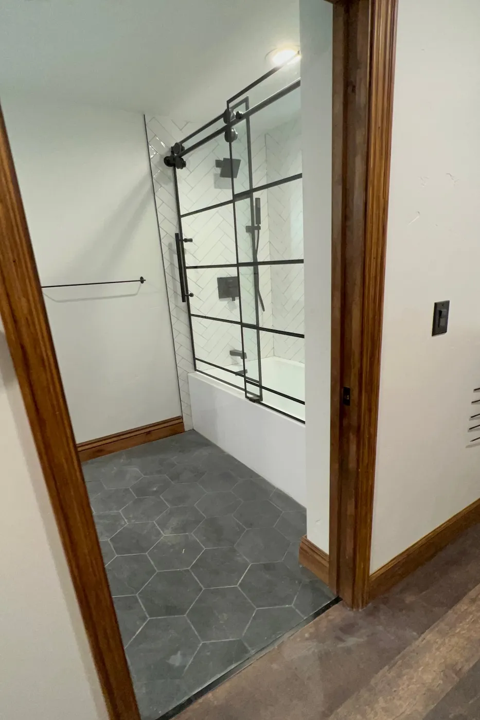 Finished basement bathroom shower and tub with herringbone tile in Boise