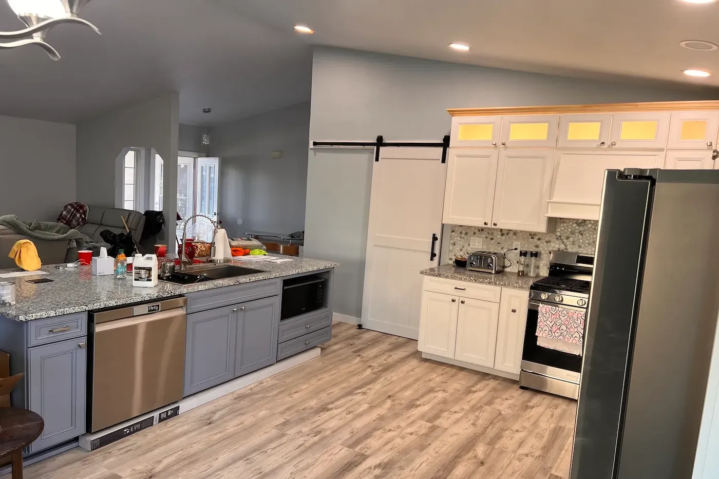 Finished open-concept Boise kitchen with island, barn door, and stone backsplash